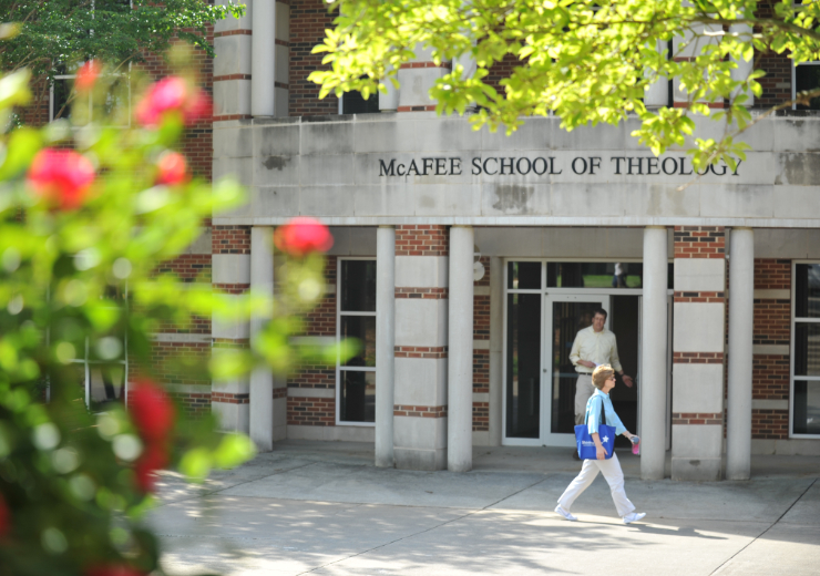 The front of the Theology School building with two students