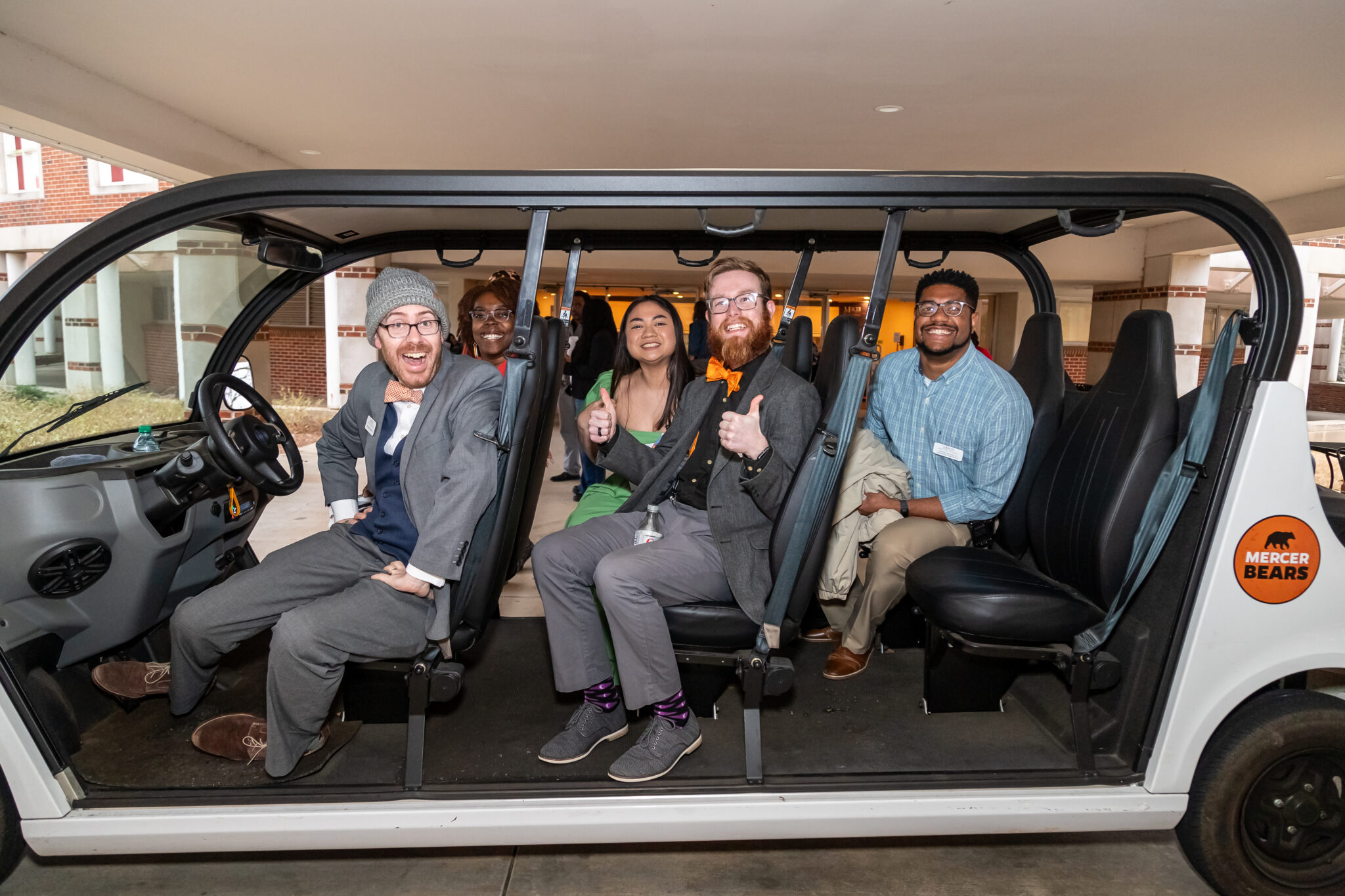 Admissions Team with a group of students on a campus visit in the extended golf cart