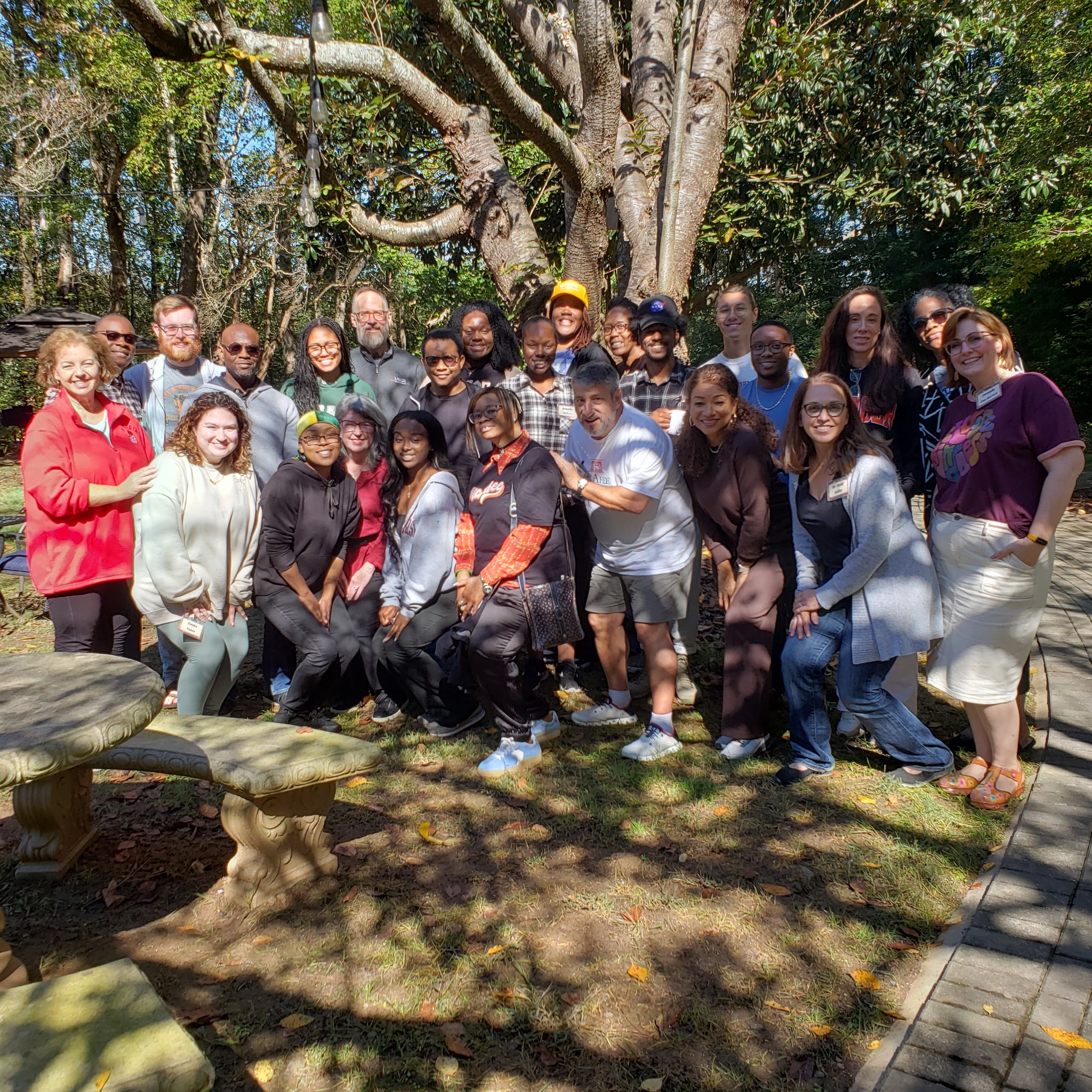 Group of students posing outside under a tree