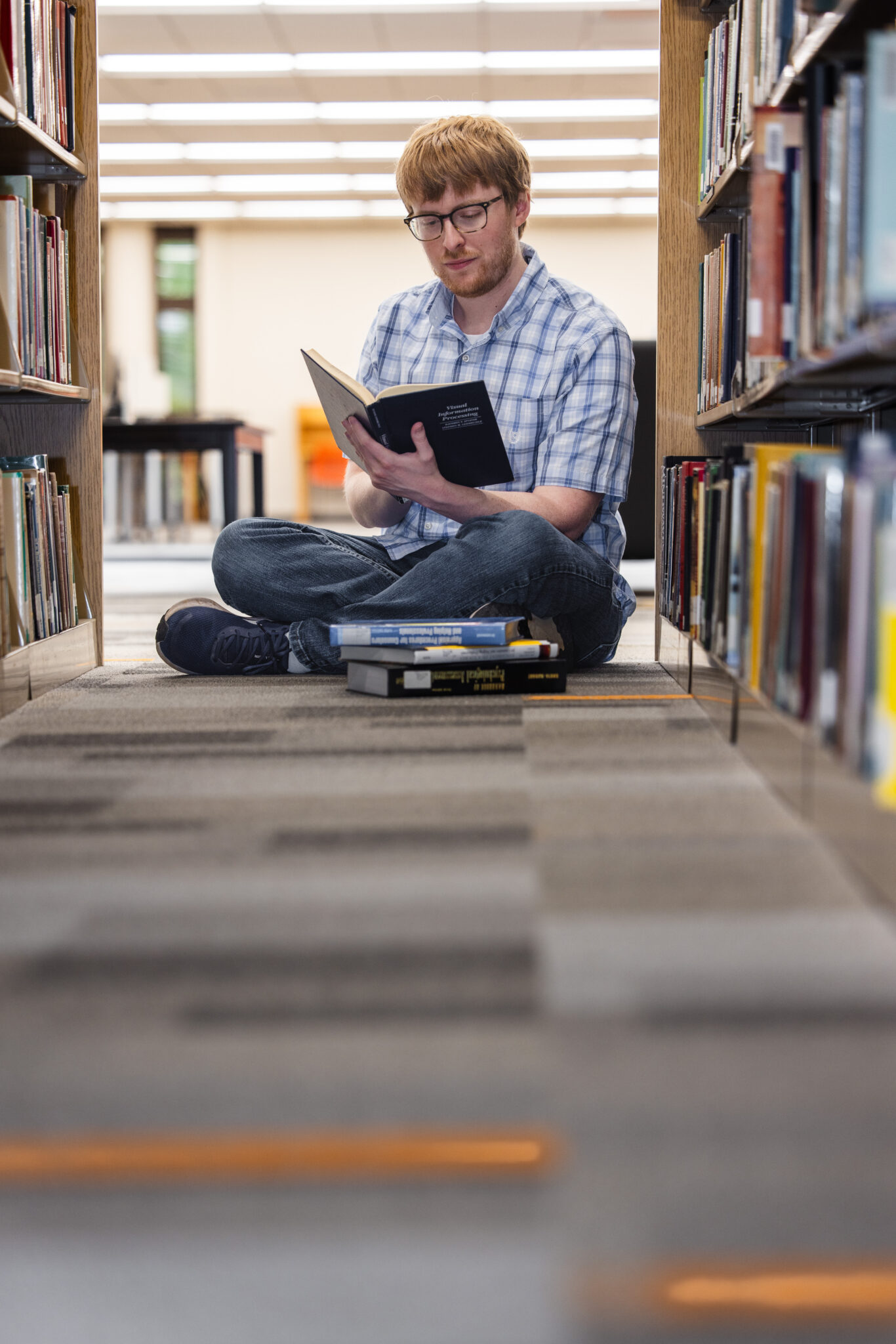 student sitting on floor reading